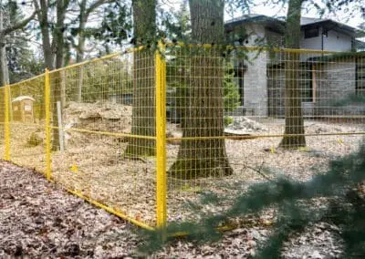Yellow temporary fence rentals surrounding a new home construction site
